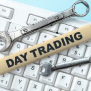 Two wrenches sit on a keyboard with a strip of wood that says "Day Trading On It"