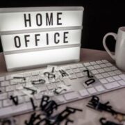 A sign behind a keyboard that reads "Home Office"